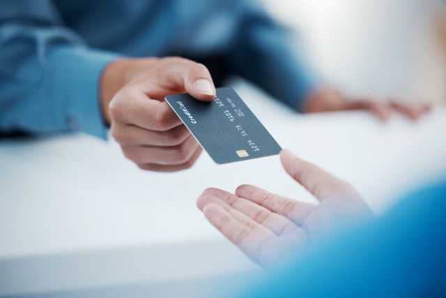 Patient handing healthcare staff a credit card to pay for doctor's visit