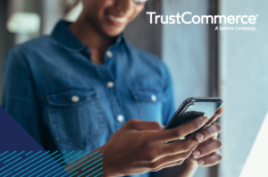 Photo of woman reading from cell phone with TrustCommerce logo on image